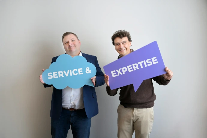 Two smiling men holding "service &" and "expertise" signs